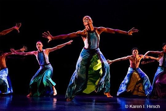 Female African-American dancer  with extended arms joyous in a group of dancers
